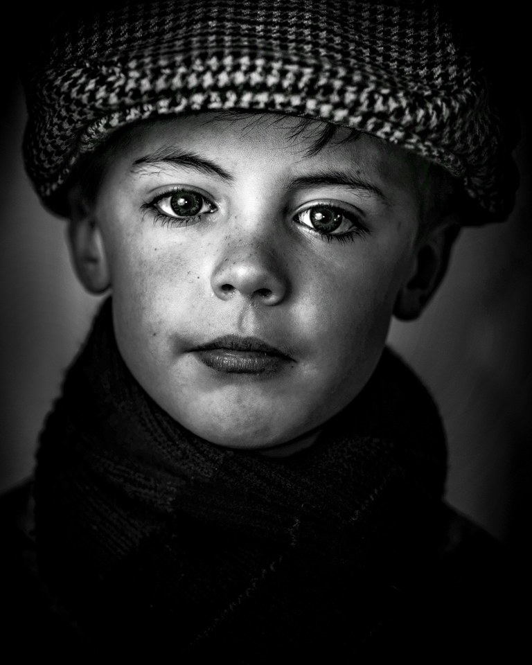 Portrait of an Irish boy with striking eyes, the ocean and far-off journeys behind his gaze.
