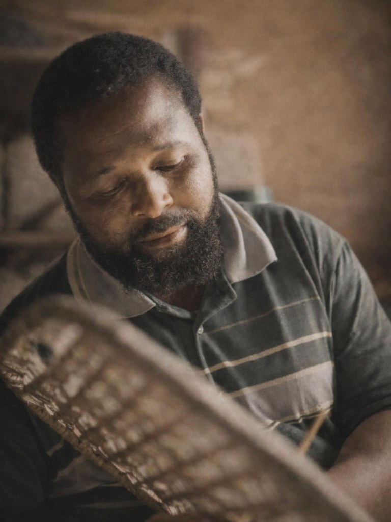 A craftsman at work in Africa, photographed after a walk down muddy dirt roads to reach his village workshop.
