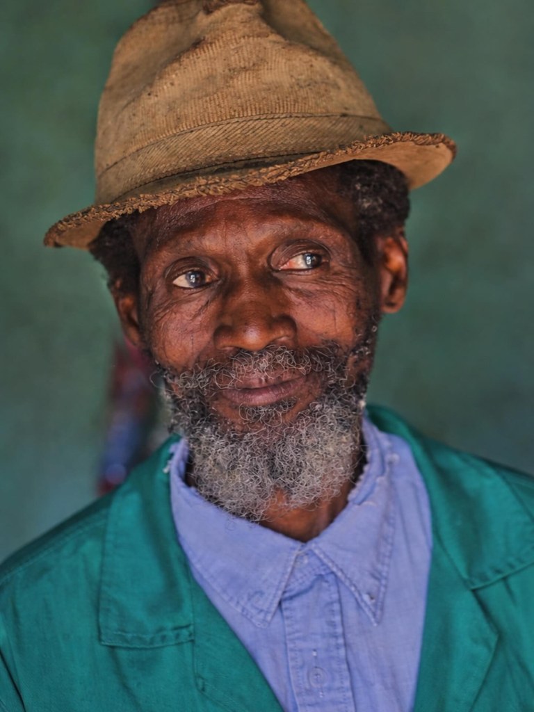 Portrait of a village chief, seated and composed, the authority of a community in one face.